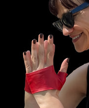 Load image into Gallery viewer, Woman with sun glasses smiling and showing her hands wearing Lamia Design handmade Red mini Gloves 
