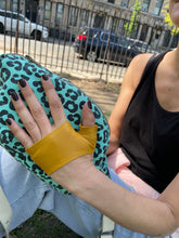 Load image into Gallery viewer, woman sitting on the grass in the Park and wearing Lamia design mustard color mini gloveswith her black nails.