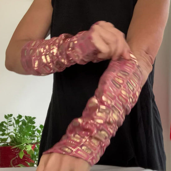 this is a product video: woman arms showing how to weare lamiadesign sleeves, lambskin leather print rectangle, gold, pink, purple lambskin sleeves