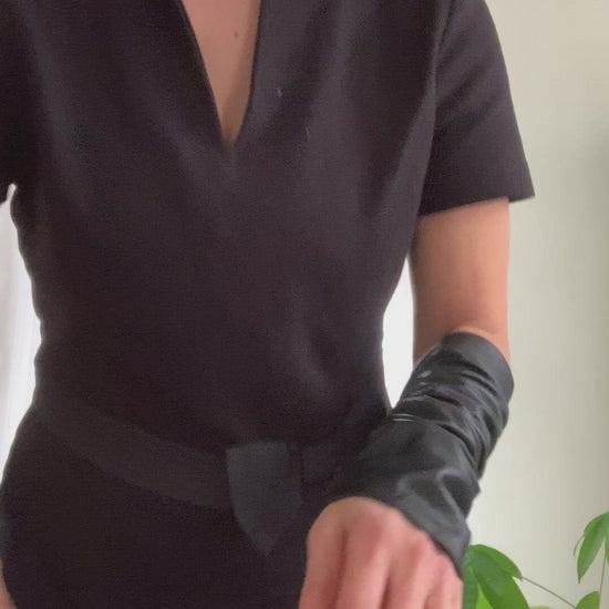 Product video: woman showing how to wear  Lamia Design black  leather sleeves  