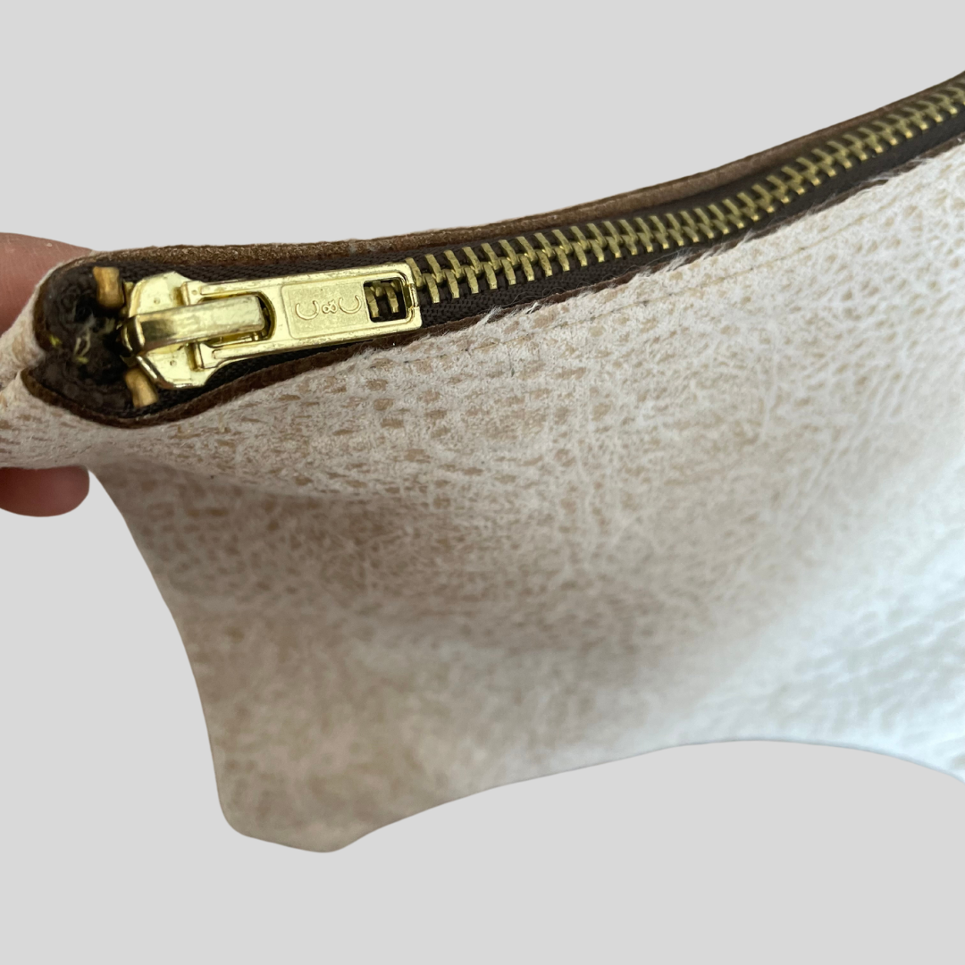 golden zipper  of the beige vegan leather bag 