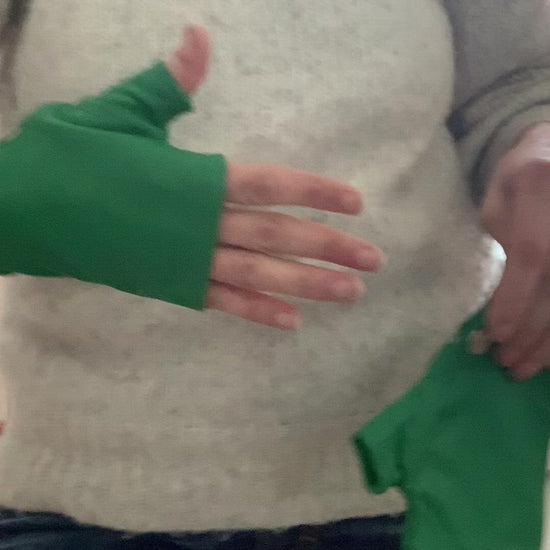 Woman hands showing lamiadesign short gloves in green with three silver snaps