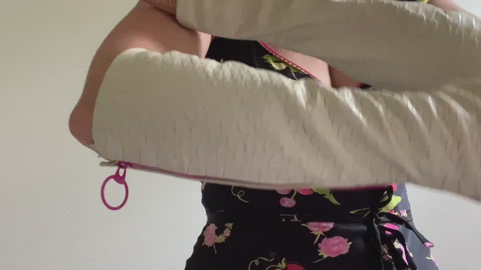 Product video: A  woman  is showing  how to wear lamia design beige snake pattern vegan leather gloves with a pink zipper. 